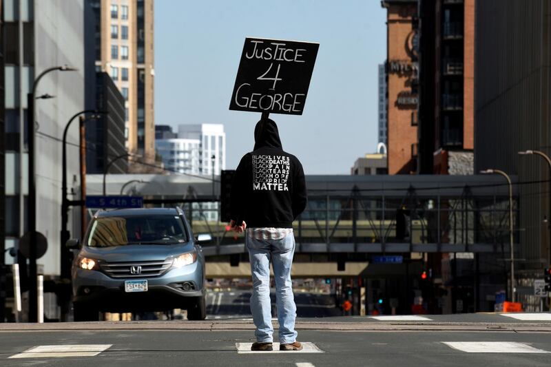 A demonstrator blocks traffic outside the Hennepin County Government Center during the first day of the trial of former police Derek Chauvin, who is facing murder charges in the death of George Floyd, in Minneapolis, Minnesota, U.S., March 29, 2021.    REUTERS/Nicholas Pfosi