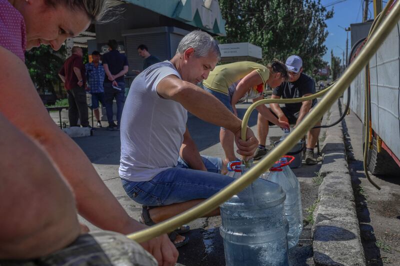 People fill up water canisters in Mykolaiv, amid the Russian invasion of Ukraine.  AFP
