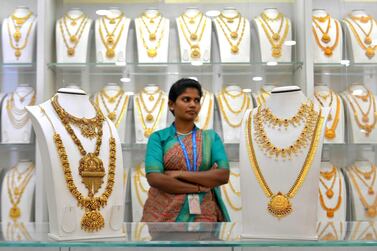 A saleswoman stands next to gold necklaces at a jewellery store in Bangalore. AFP