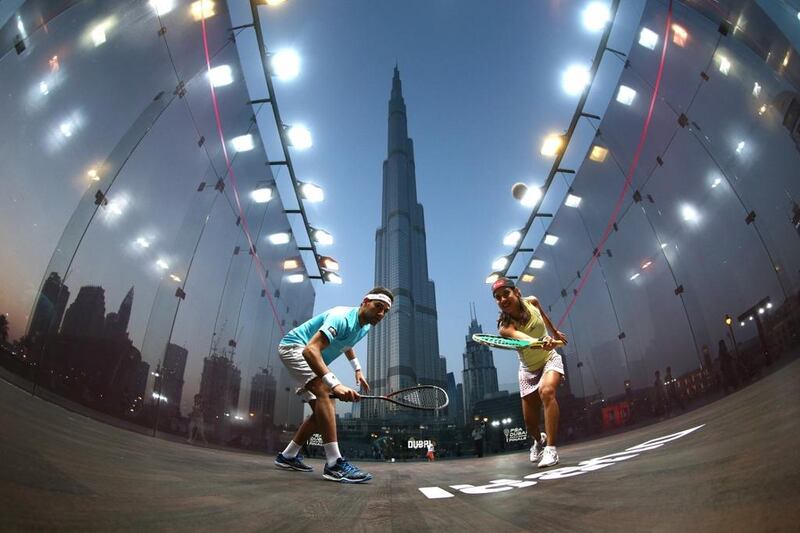 Nicol David, right, and Mohamed Elshorbagy play squash with the Burj Khalifa in the background. Courtesy UAE Squash Association