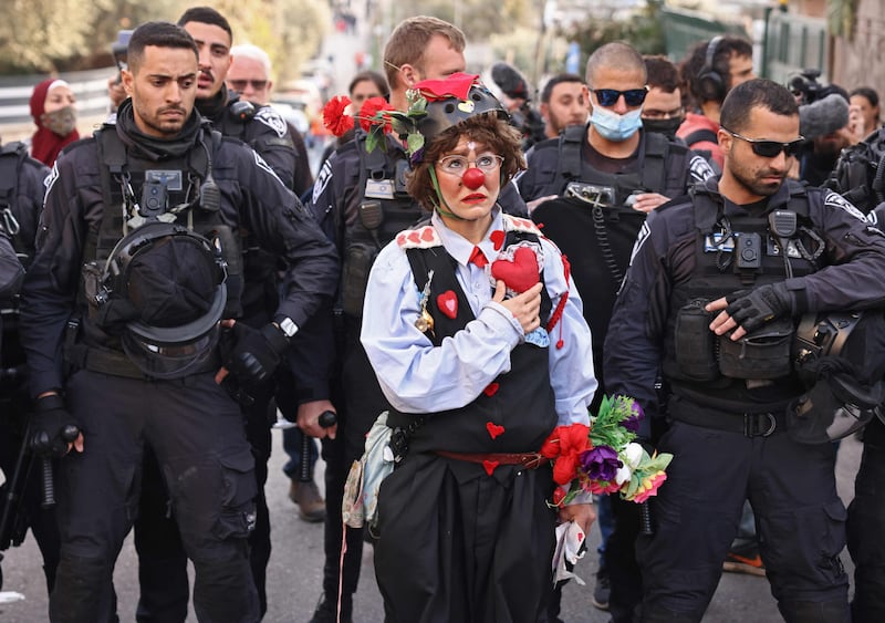 Az-Oolay the clown in front of Israeli police officers during a demonstration in the Sheikh Jarrah neighbourhood of occupied East Jerusalem, in February. AFP