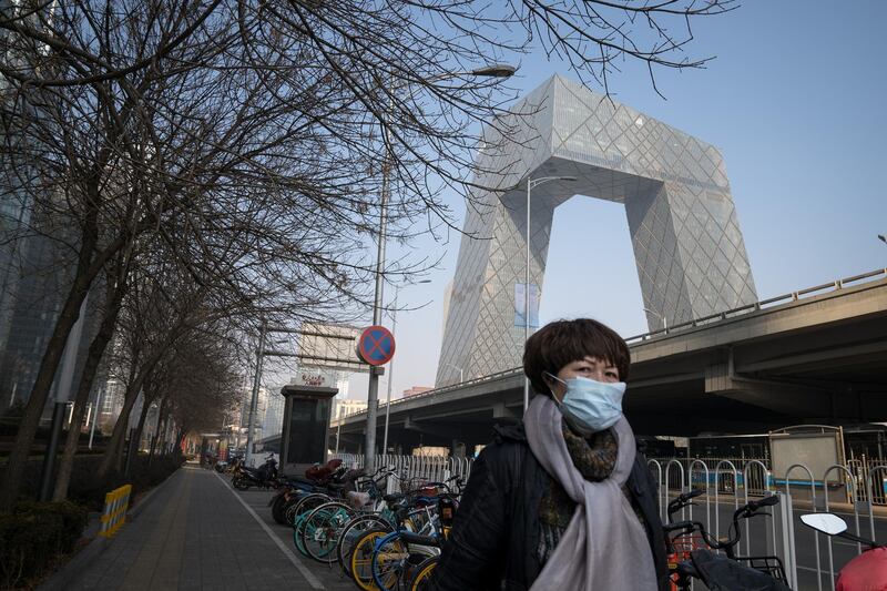 BEIJING, CHINA - FEBRUARY 10: A woman walks by the iconic CCTV headquarters, in Central Business District, on February 10, 2020 in Beijing, China. February 10 marks the end of the Chinese New Year holidays, that were extended due to the outbreak of novel coronavirus, however, the Chinese capital remains empty and business does not seem to resume. (Photo by Andrea Verdelli/Getty Images)