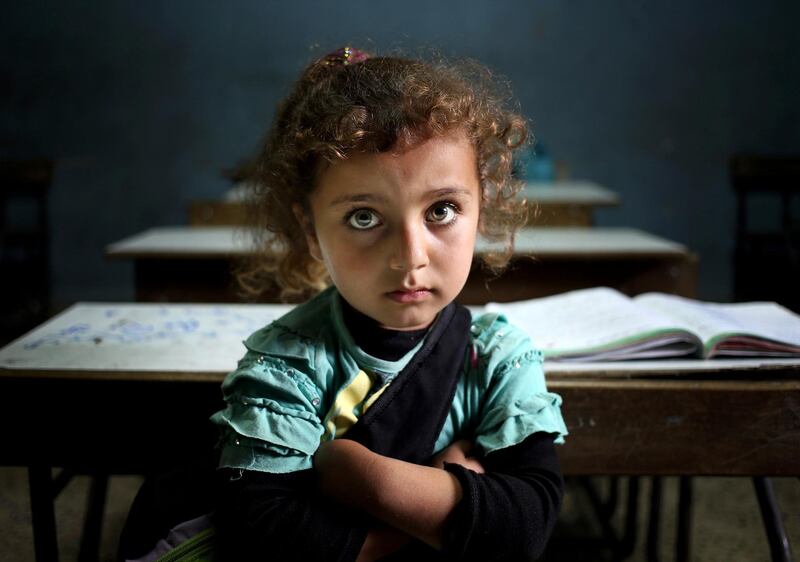 FILE - In this Thursday, May 29, 2014 file photo, a Syrian refugee girl sits in a classroom at a Lebanese public school where only Syrian students attend classes in the afternoon, at Kaitaa village in north Lebanon. A new report by Human Rights Watch said Thursday, Sept. 14, 2017 that millions of dollars of school aid for Syrian refugee children went unaccounted for last school year, leaving schools across the region understaffed and contributing to a massive under-enrollment of Syrian school children. (AP Photo/Hussein Malla, File)