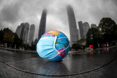 A model of the globe with a face mask in Guangzhou to mark World Earth Day on April 22. One highlight of the pandemic is global emissions dropped 8% in the first few months of 2020. EPA