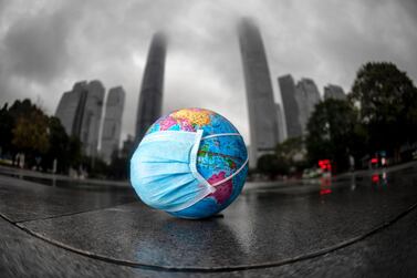 A model of the globe with a face mask in Guangzhou to mark World Earth Day on April 22. One highlight of the pandemic is global emissions dropped 8% in the first few months of 2020. EPA