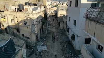 People stand on a destroyed street after an Israeli army raid in the West Bank city of Jenin on July 5. EPA