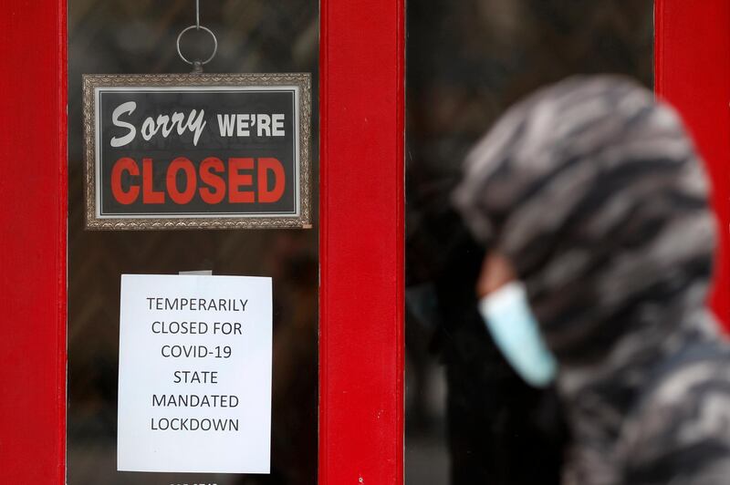 FILE - In this May 7, 2020 file photo, a pedestrian walks by The Framing Gallery, closed due to the COVID-19 pandemic, in Grosse Pointe, Mich. The U.S. unemployment rate hit 14.7% in April, the highest rate since the Great Depression, as 20.5 million jobs vanished in the worst monthly loss on record. The figures are stark evidence of the damage the coronavirus has done to a now-shattered economy.. (AP Photo/Paul Sancya, File)