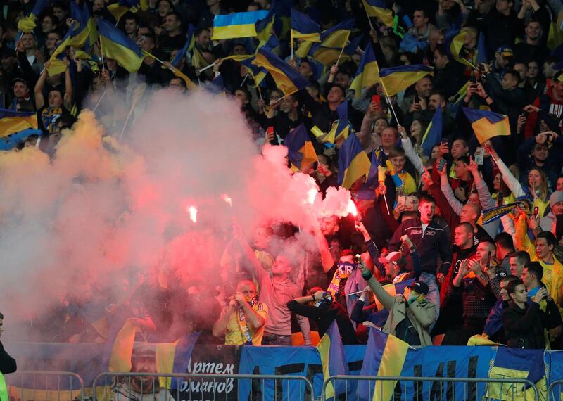 Ukraine fans light flares inside the stadium after Roman Yaremchuk scores. Reuters