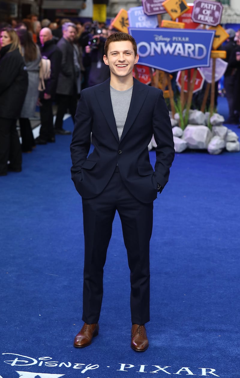 Tom Holland, in a grey T-shirt and navy Enzo suit, attends the 'Onward' UK premiere in London on February 23, 2020. Getty Images