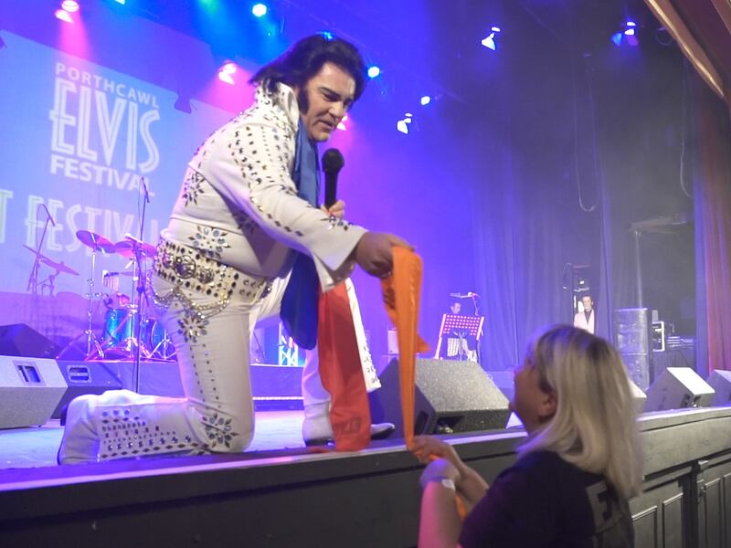 Victor Andrews hands out a scarf to a fan while performing at Porthcawl's Grand Pavilion.