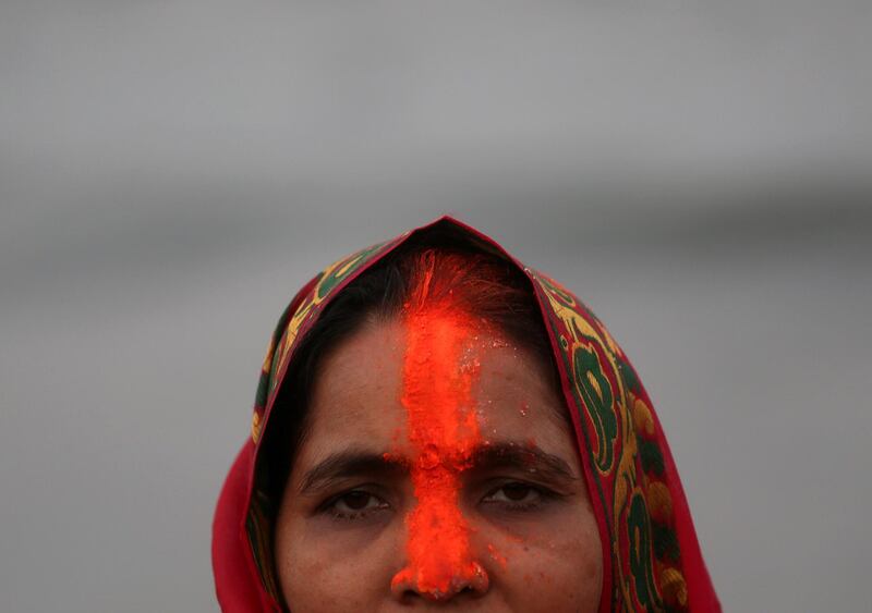 A Hindu devotee with 'sindhur', or vermillion powder, on her forehead worships the Sun god in the waters of the Arabian Sea in Mumbai. Reuters