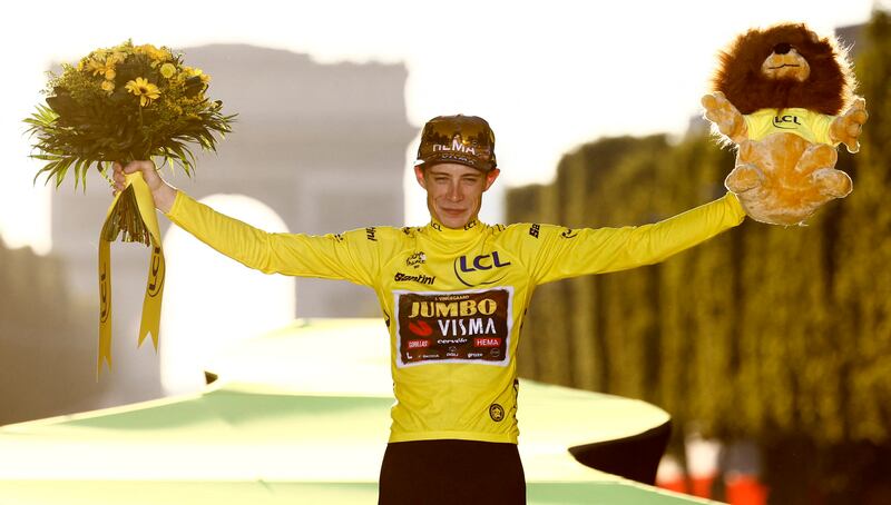 Cycling - Tour de France - Stage 21 - Paris La Defense Arena to Champs-Elysees - France - July 24, 2022 Jumbo - Visma's Jonas Vingegaard celebrates on the podium wearing the overall leader's yellow jersey after winning the Tour de France REUTERS / Christian Hartmann