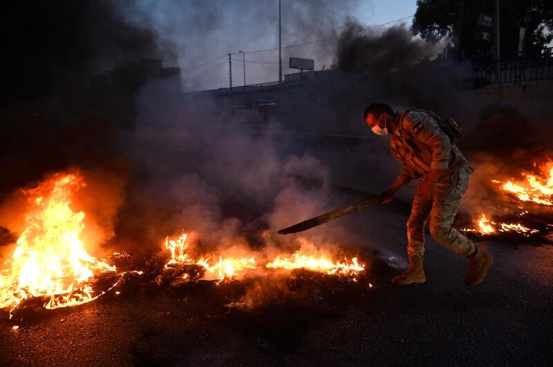 A Lebanese soldier tries to re-open the main motorway leading to Rafik Hariri International Airport that was blocked by anti-government protesters. EPA