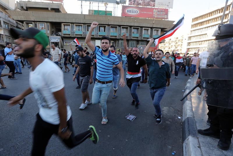 Iraqi protesters run as they try to reach to the gate of the the fortified green zone which is the headquarters of the Iraqi government during a demonstration at Tahrir square, central Baghdad. EPA