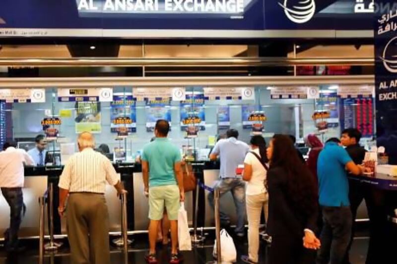 Customers transferring money at an exchange in the UAE. The National
