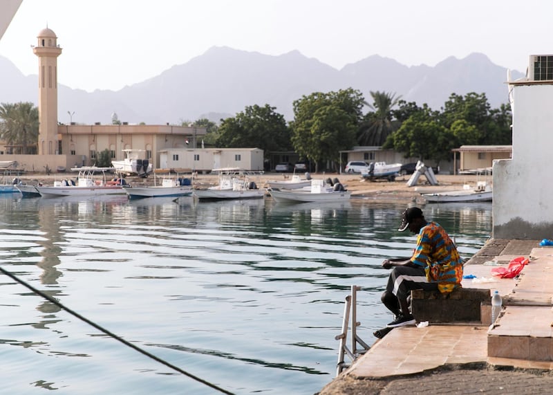 FUJAIRAH, UNITED ARAB EMIRATES. 3 AUGUST 2020. Two men fish in Dibba Al Fujairah’s port.The UAE is calling on more volunteer divers to help restore and replant coral reefs in the open waters of Fujairah.Over the next five days, teams of volunteers will take fresh coral from Dibba Fujairah Port and replant it further out at sea, about 1km from Dibba Rock, a popular diving spot in the emirate.  The campaign is part of an initiative by the Ministry of Climate Change and Environment and Fujairah Adventure Centre to help sustain and grow marine life in UAE waters.(Photo: Reem Mohammed/The National)Reporter:Section: