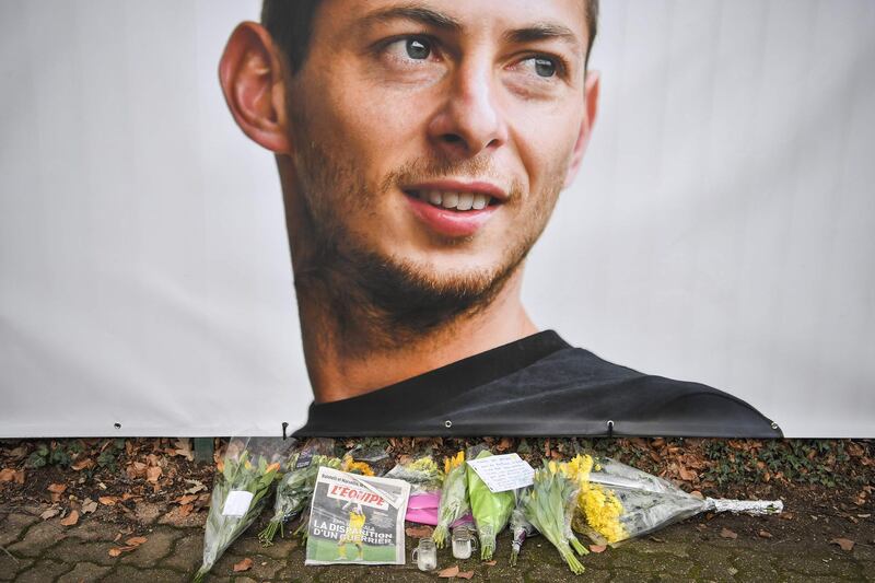 Flowers and candles are left with the French sports daily newspaper 'L'Equipe' next to a portrait of Sala in front of the entrance of the FC Nantes football club training center La Joneliere in La Chapelle-sur-Erdre, France. AFP