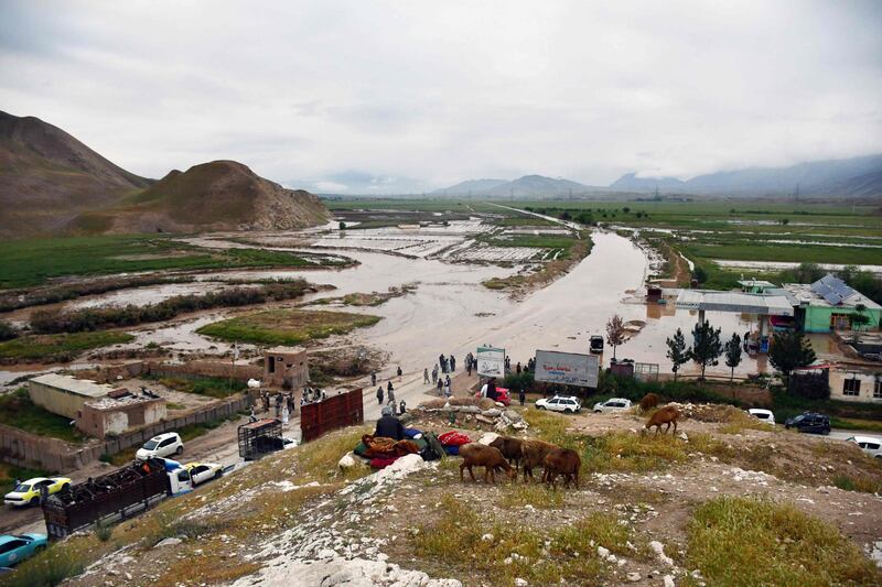 Afghan people gather along a flooded road in the Feroz Nakhchir district of Samangan province. AFP