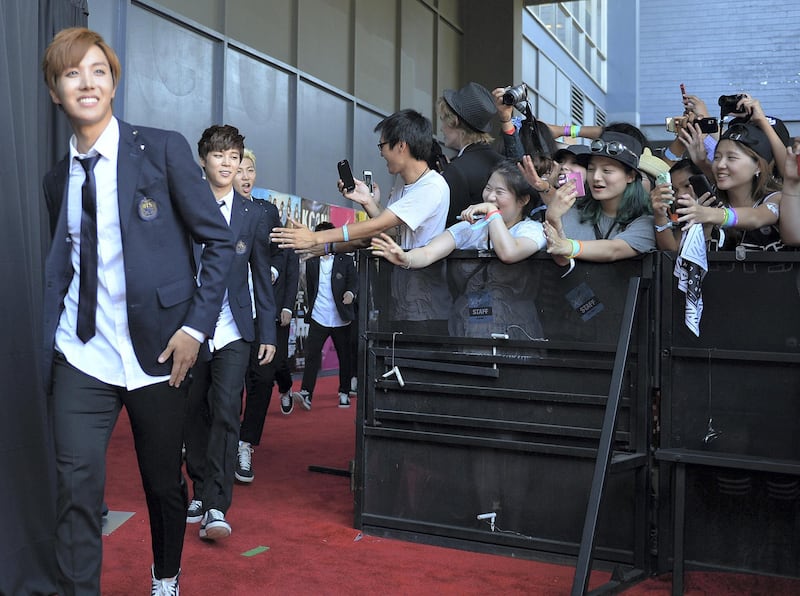 Members of Korean K-pop group BTS arrive on the red carpet during the K-CON 2014 (Korean Culture Convention) at the Los Angeles Memorial Sports Arena on August 10, 2014.  Having taken Asia by storm over the past decade with bubblegum looks and dance moves infused with military precision, South Korea's K-pop phenomenon continues to defy cultural barriers and find fans around the world. More Korean bands have multilingual members who can sing verses, carry choruses, and conduct interviews in English, Chinese, and Japanese so language is no longer a barrier.            AFP PHOTO/Mark RALSTON (Photo by MARK RALSTON / AFP)