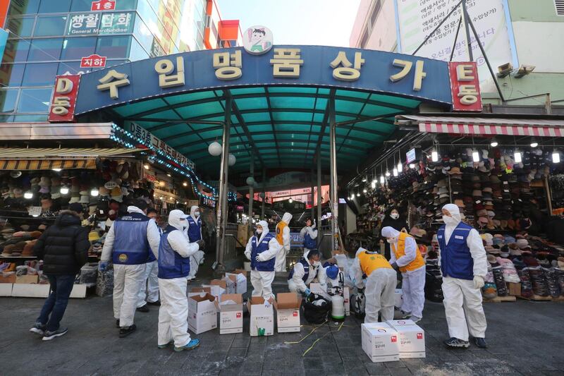Workers wearing protective gear prepare to spray disinfectant as a precaution against a new coronavirus at Namdaemun Market in Seoul, South Korea. AP Photo
