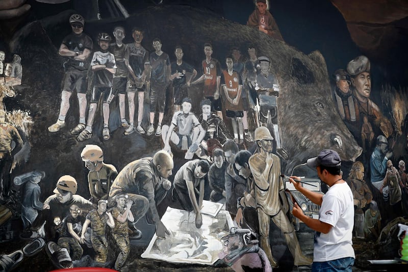 A Thai artist works on a giant painting on the recuse mission to save 12 soccer boys and their coach at Tham Luang cave complex, in Chiang Rai province, northern Thailand. AP Photo