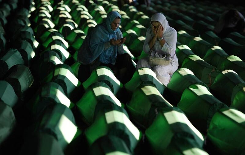 Bosnian Muslim women mourn among the 613 coffins laid out in preparation for a mass burial ceremony at the Srebrenica Memorial Cemetery in Potocari. Andrej Isakovic / AFP