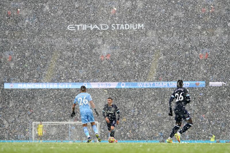 West Ham United's Aaron Cresswell on the ball as heavy snow falls onto the pitch. AFP