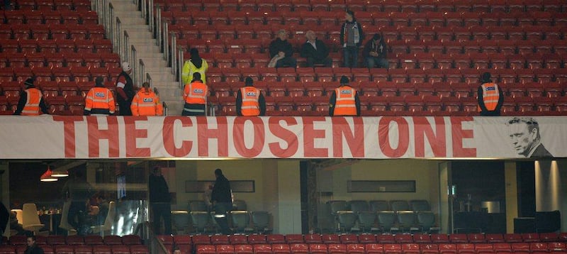Stewards stand by the banner depicting Manchester United manager David Moyes at the final whistle after their 0-3 defeat to Manchester City on Tuesday. Paul Ellis / AFP / March 25 , 2014