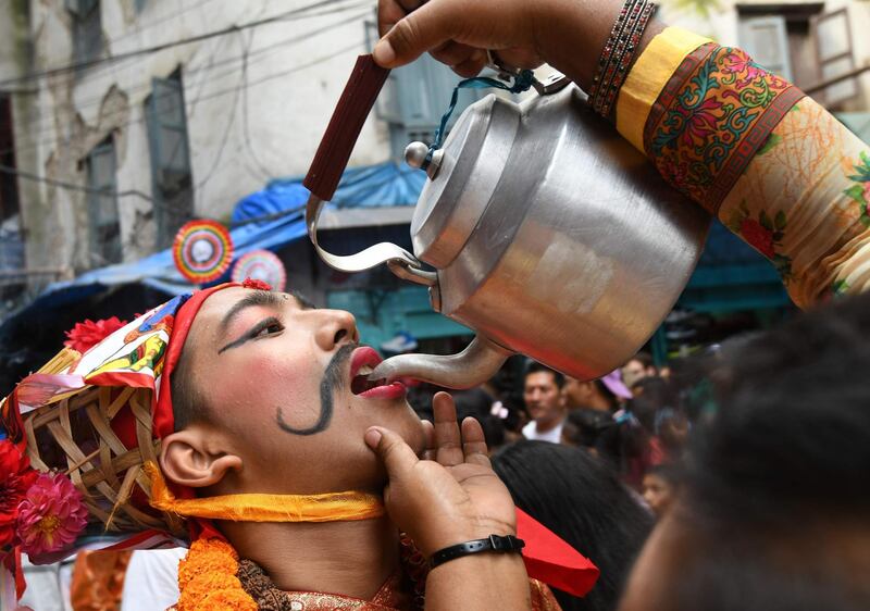 A Nepali woman pours milk into a boy's mouth during a procession for Gai Jatra, the festival of cows, in Kathmandu, Nepal. Prakash Mathema / AFP