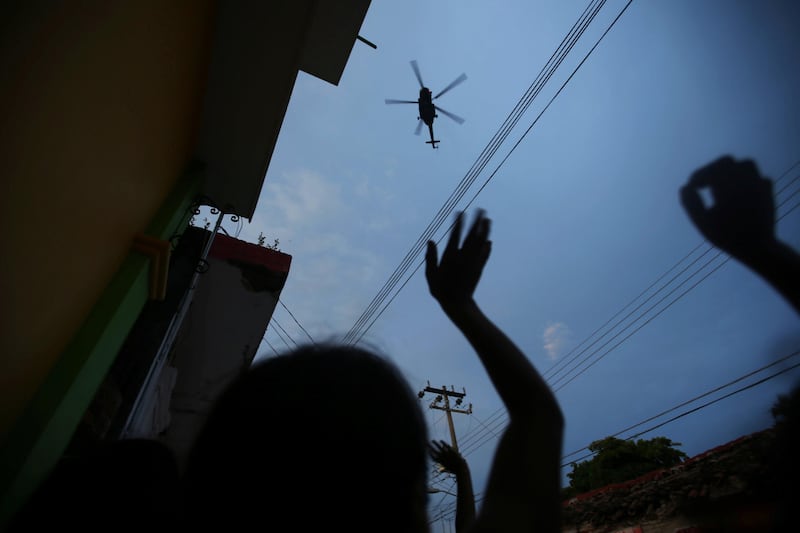 People wave at a helicopter after an earthquake that struck off the southern coast of Mexico. Edgard Garrido / Reuters