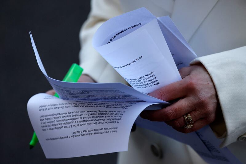A journalist highlights sections of the report by civil servant Sue Gray into parties held at Downing Street. AFP