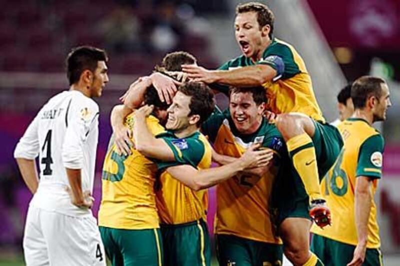Robbie Kruse, second left, celebrates with his Australia teammates after scoring their sixth goal against Uzbekistan.