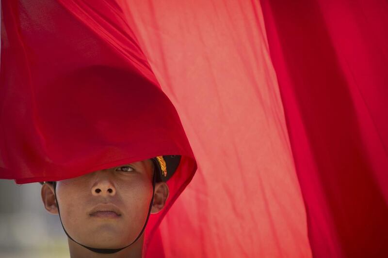 A member of a Chinese honor guard stands with a flag before a welcome ceremony for Canada’s Prime Minister Justin Trudeau at the Great Hall of the People in Beijing. Mark Schiefelbein / AP