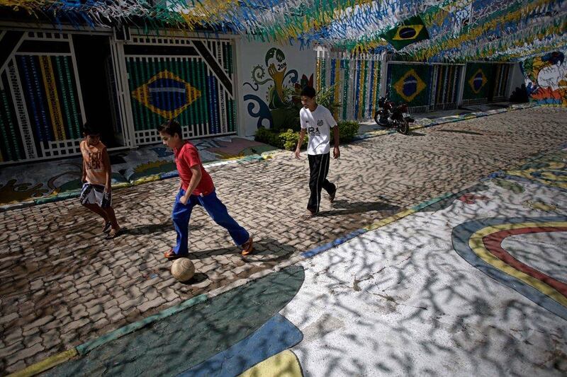 Boys play ball in a street decorated for the upcoming 2014 World Cup on Wednesday outside Brasilia, Brazil. Eraldo Peres / AP / June 4, 2014