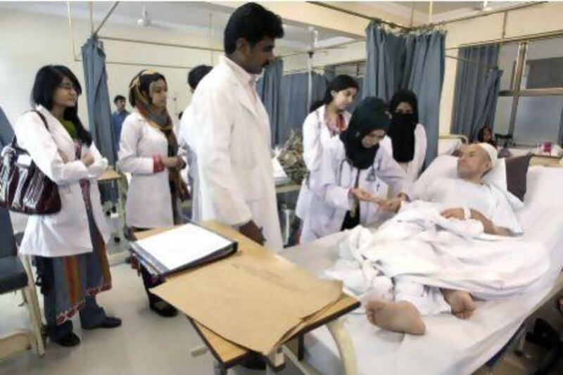 A female Pakistani doctor examines a patient at the Dow Medical Institute for Health in Karachi.