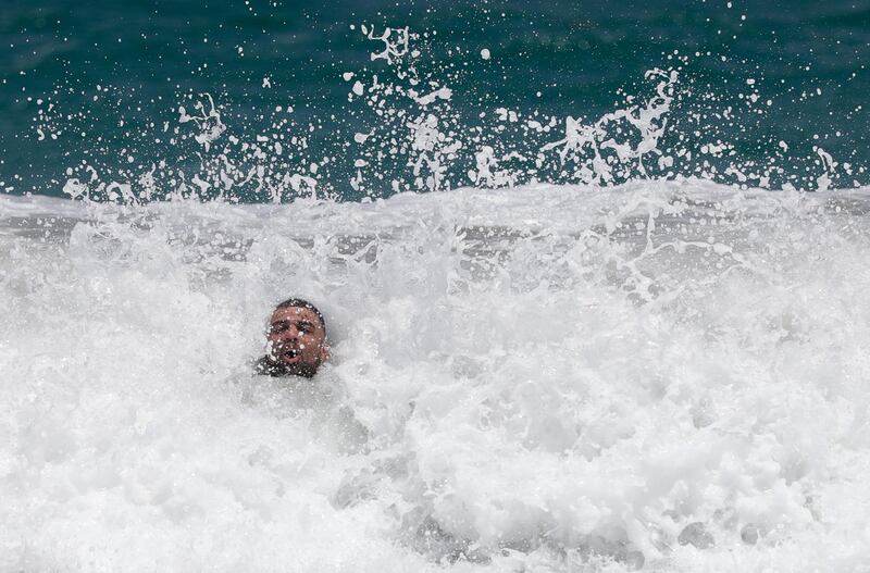 A beachgoer is engulfed by a wave as he jumps in the surf, in Palm Beach, Florida. AP Photo