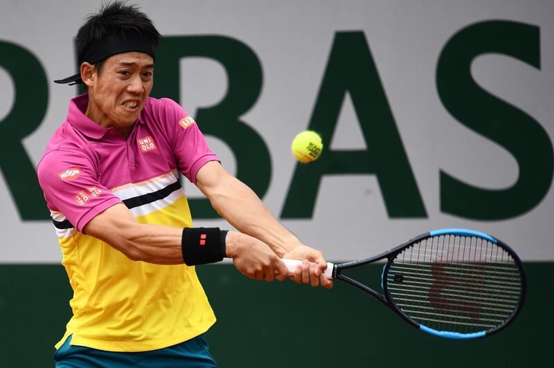 Japan's Kei Nishikori plays a backhand return France's Quentin Halys during their men's singles first round match on day 1 of The Roland Garros 2019 French Open tennis tournament in Paris on May 26, 2019. / AFP / Martin BUREAU
