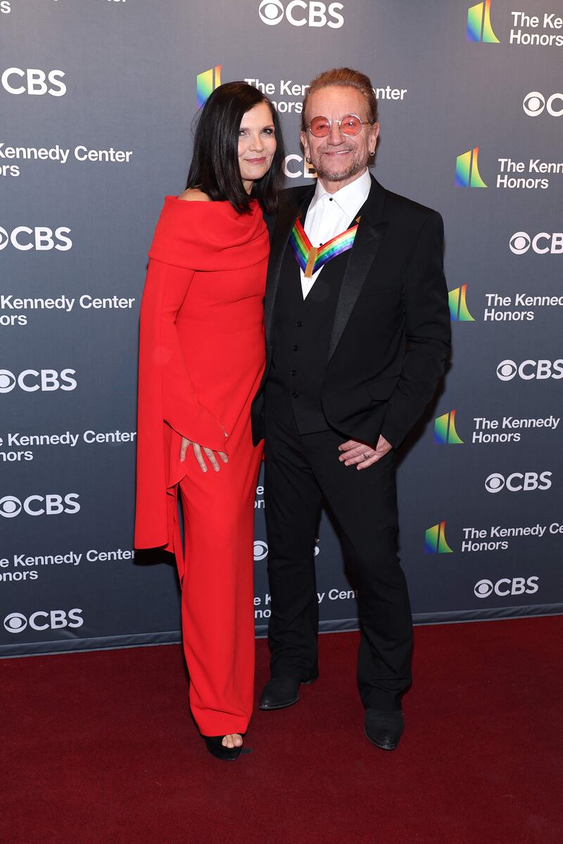 Honouree Bono and his wife, Ali Hewson, wearing a red dress with caped sleeves. AFP 
