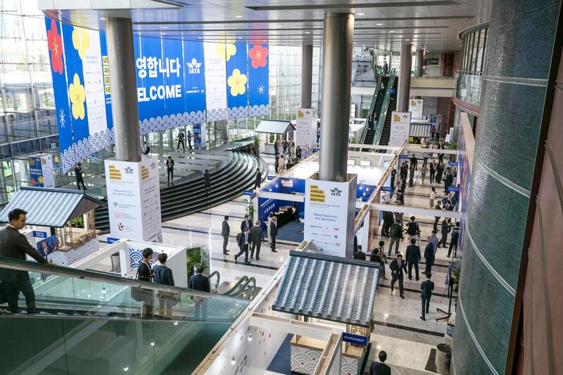 Attendees walk past booths at the IATA annual general meeting in Seoul, South Korea. Bloomberg