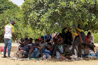 Sub-Saharan migrants rest under the shade of a tree to avoid the heat. AFP
