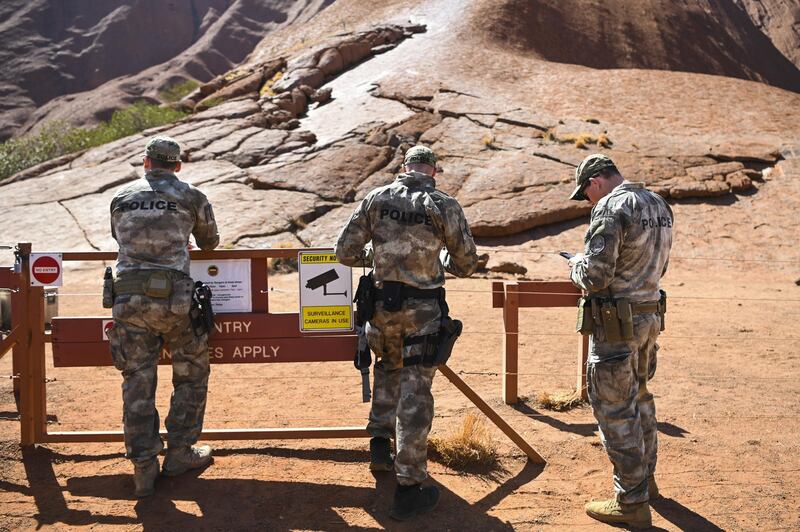 Police officers patrol the area surrounding Uluru. EPA