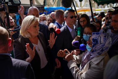 French far-right leader Marine Le Pen, left, talks to a woman while campaigning in Pertuis, southern France, Friday, April 15, 2022.  AP Photo
