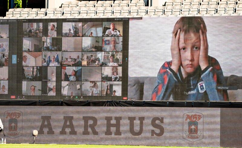 A young fan holds his head as fans are streamed live on to the screens on the sidelines during the 3F Super League football match between AGF and Randers FC. AFP