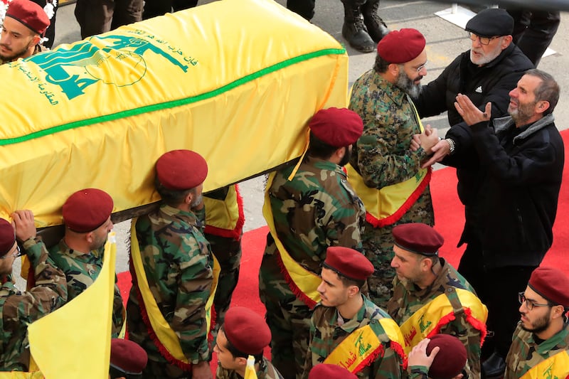 Ahmad Bazzi, right, mourns as Hezbollah fighters carry the coffin of one of his sons, in Bint Jbeil. AP