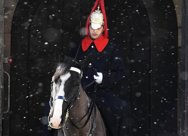 A member of the Household Cavalry on his horse on guard duty at Horseguards Parade as the snow falls in central London. Andy Rain / EPA