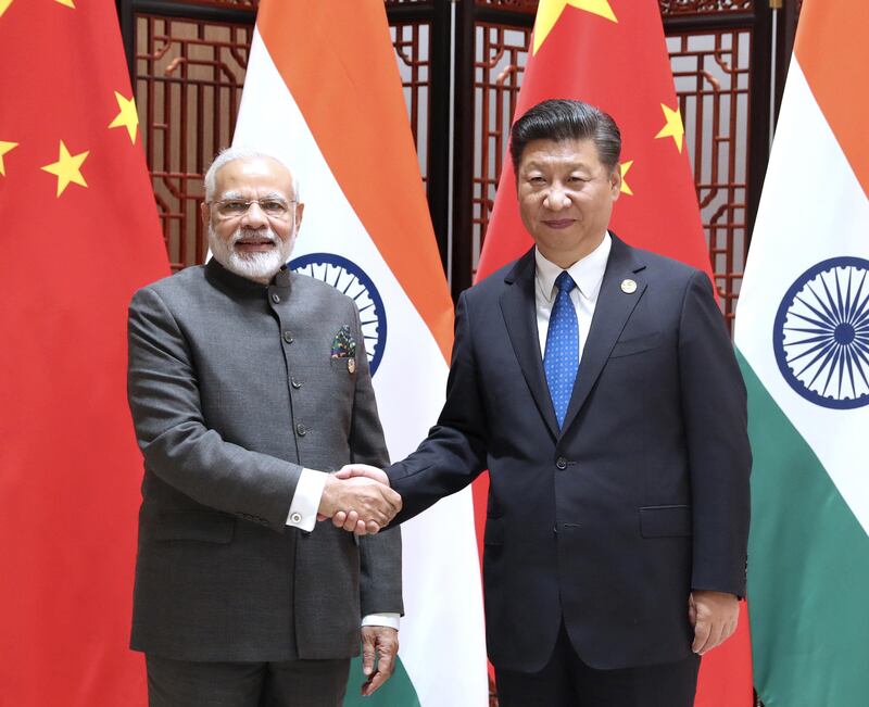 In this photo released by China's Xinhua News Agency, Indian Prime Minister Narendra Modi, left, and China's President Xi Jinping shake hands as they pose for a photo during a meeting on the sidelines of the BRICS Summit in Xiamen in southeastern China's Fujian Province, Tuesday, Sept. 5, 2017. India's foreign secretary says the leaders of China and India have emphasized that peace and tranquility in their border areas is a "prerequisite" for the further development of their relationship. (Ma Zhancheng/Xinhua via AP)