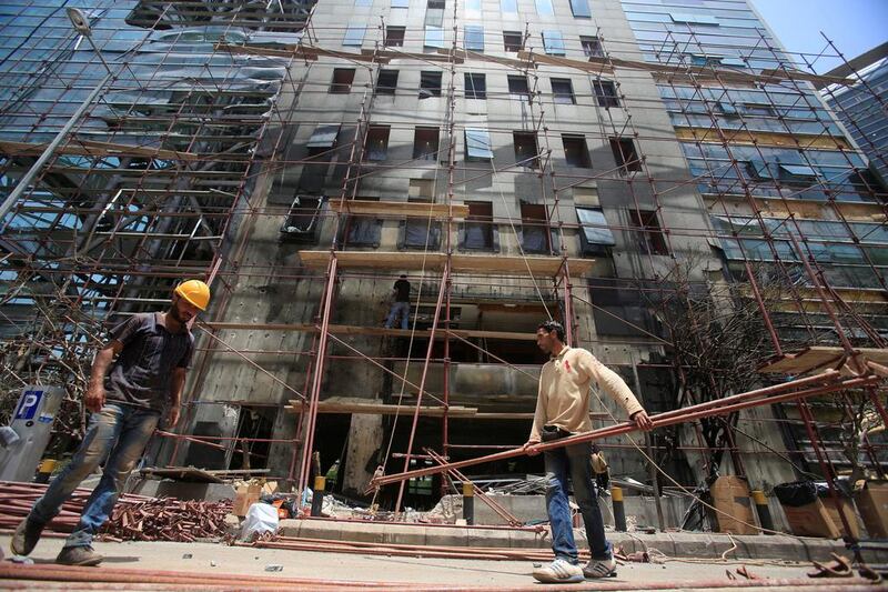 Workers repair the facade of the headquarters of the Lebanese Blom Bank that was struck by a bomb last week. Jamal Saidi / Reuters