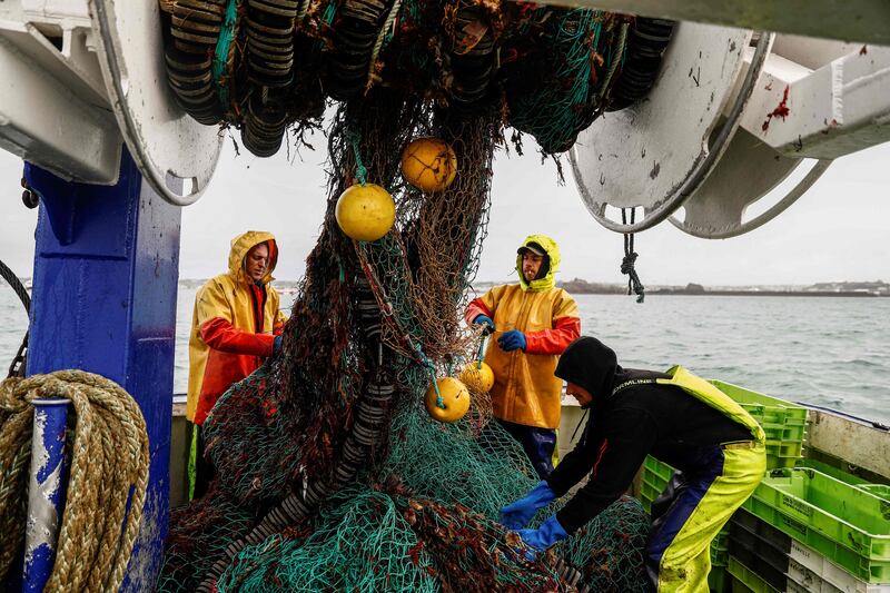 French fishermen bring in a net near the port of Saint Helier, on the British island of Jersey, in May. Photo: AFP