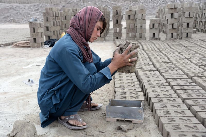 This photograph taken on March 11, 2018 shows Afghan female labourer Sitara Wafadar, 18, who dresses as a male in order to support her family, working at a brick factory in Sultanpur village in Surkh Rod district, in Afghanistan's eastern Nangarhar province.
Sitara Wafadar yearns for long hair like other girls. Instead, the Afghan teenager has disguised herself as a boy for more than a decade, forced by her parents to be the "son" they never had. / AFP PHOTO / Noorullah SHIRZADA / TO GO WITH Afghanistan-children-gender, FEATURE by Noorullah Shirzada