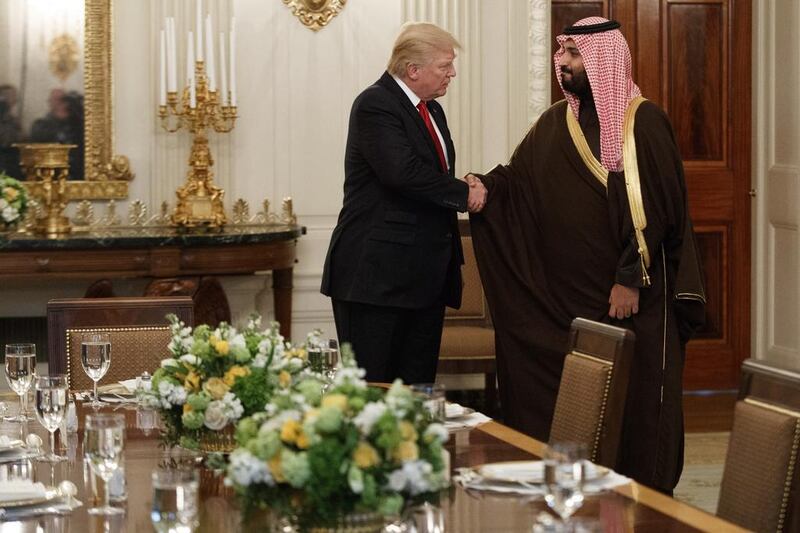 President Donald Trump shakes hands with Saudi Defense Minister and Deputy Crown Prince Mohammed bin Salman in the State Dining Room of the White House in Washington. Evan Vucci / AP